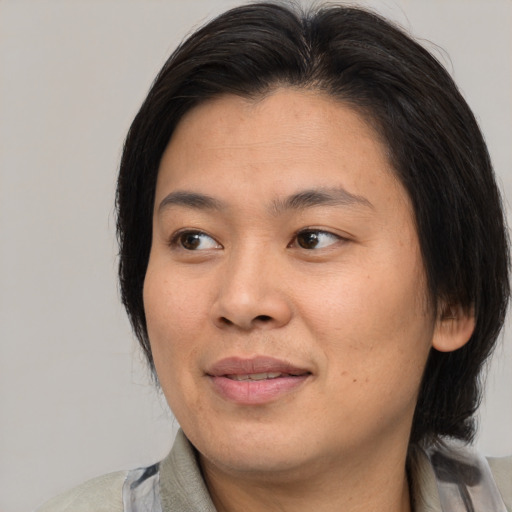 Joyful asian adult female with medium  brown hair and brown eyes
