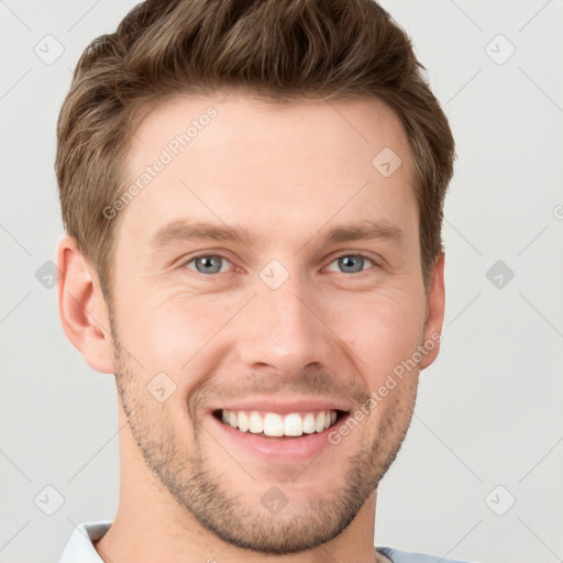 Joyful white young-adult male with short  brown hair and grey eyes