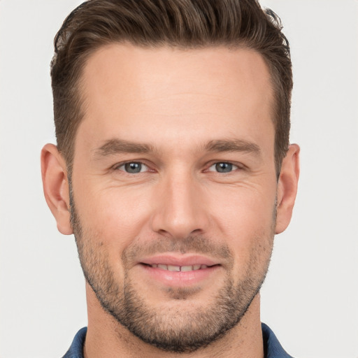 Joyful white young-adult male with short  brown hair and grey eyes