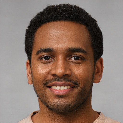 Joyful black young-adult male with short  black hair and brown eyes