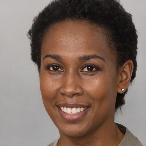 Joyful black young-adult female with short  brown hair and brown eyes