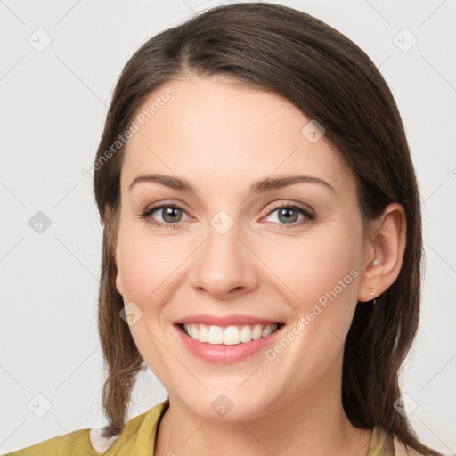 Joyful white young-adult female with medium  brown hair and grey eyes