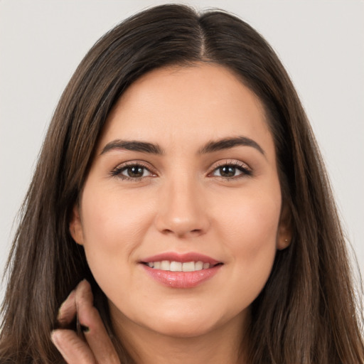 Joyful white young-adult female with long  brown hair and brown eyes