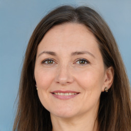 Joyful white adult female with long  brown hair and brown eyes