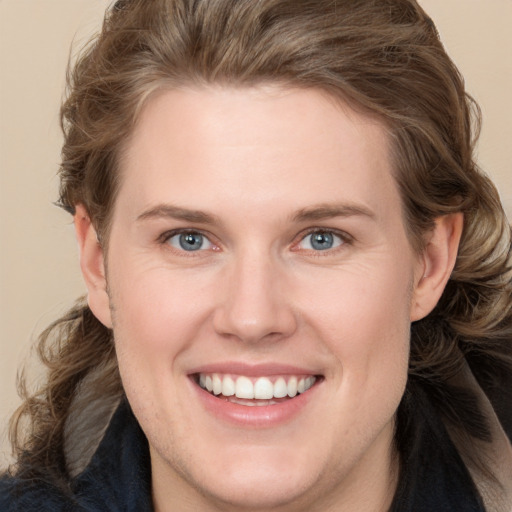 Joyful white young-adult female with long  brown hair and blue eyes