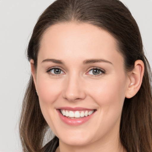 Joyful white young-adult female with long  brown hair and grey eyes