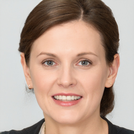 Joyful white young-adult female with medium  brown hair and grey eyes