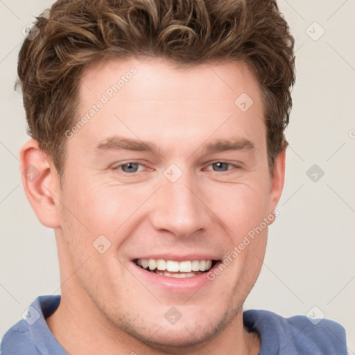 Joyful white young-adult male with short  brown hair and blue eyes