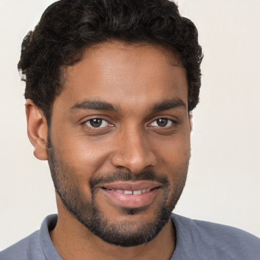 Joyful black young-adult male with short  brown hair and brown eyes