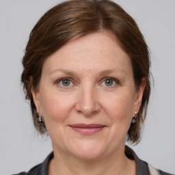 Joyful white adult female with medium  brown hair and grey eyes