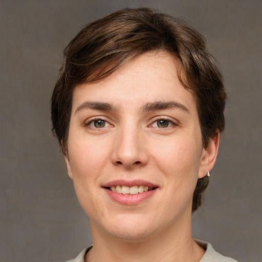 Joyful white young-adult female with short  brown hair and grey eyes