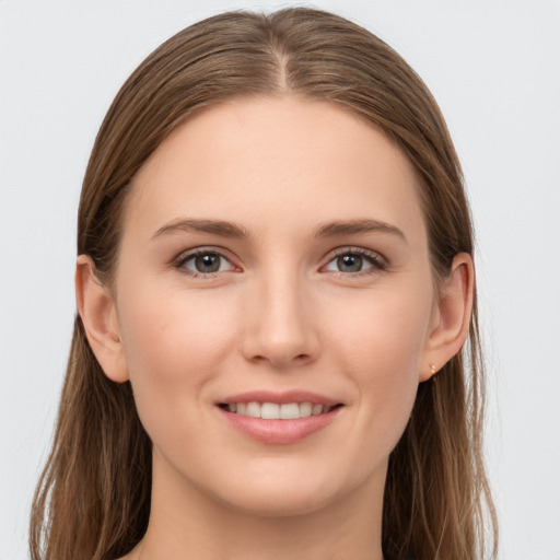 Joyful white young-adult female with long  brown hair and grey eyes