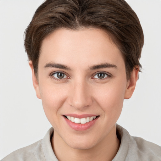 Joyful white young-adult female with short  brown hair and grey eyes