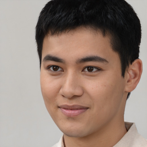 Joyful asian young-adult male with short  brown hair and brown eyes