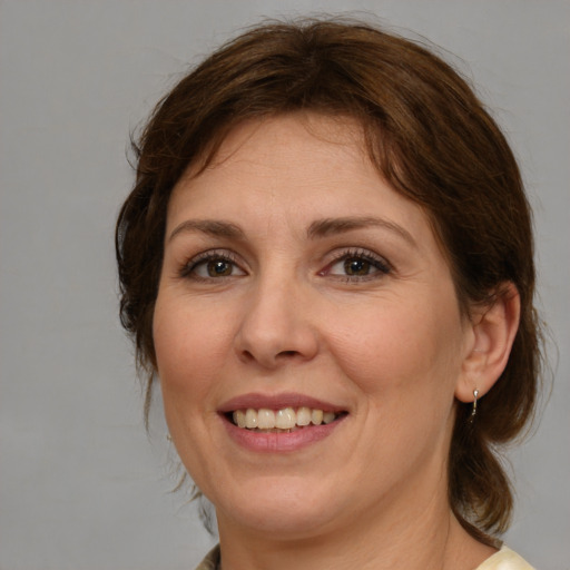 Joyful white young-adult female with medium  brown hair and green eyes