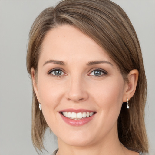 Joyful white young-adult female with medium  brown hair and grey eyes