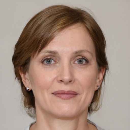 Joyful white adult female with medium  brown hair and grey eyes