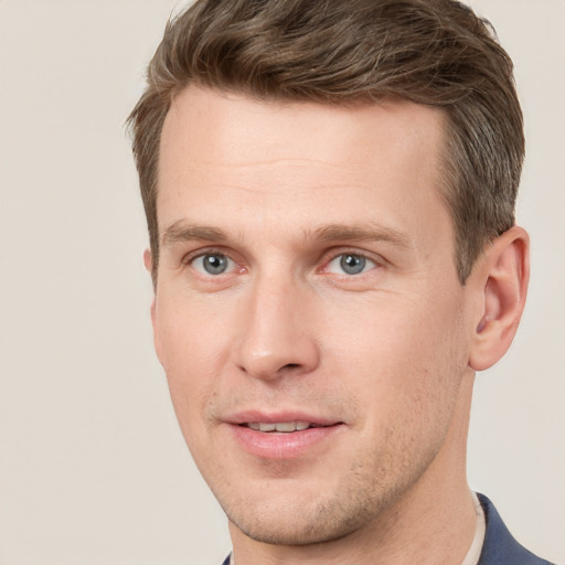 Joyful white young-adult male with short  brown hair and grey eyes