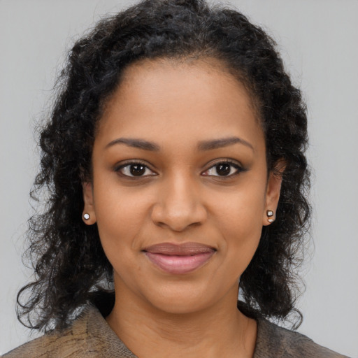 Joyful black young-adult female with long  brown hair and brown eyes