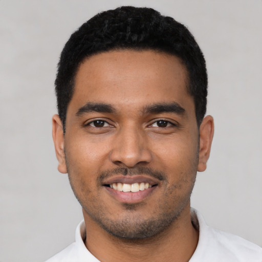 Joyful latino young-adult male with short  black hair and brown eyes