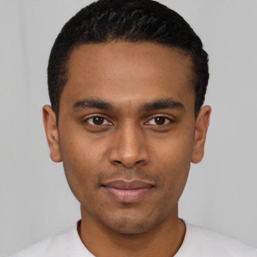 Joyful black young-adult male with short  black hair and brown eyes