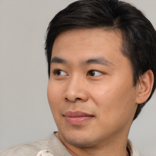 Joyful asian young-adult male with short  black hair and brown eyes
