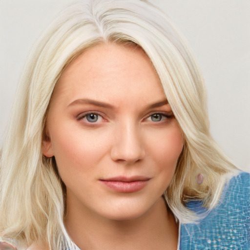 Joyful white young-adult female with long  blond hair and blue eyes