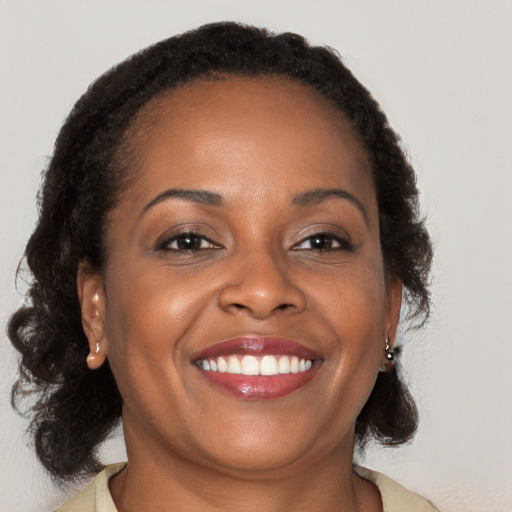 Joyful black young-adult female with medium  brown hair and brown eyes