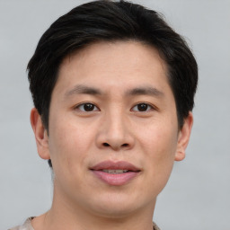 Joyful asian young-adult male with short  brown hair and brown eyes