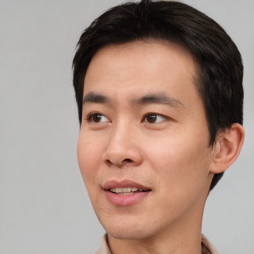 Joyful asian young-adult male with short  brown hair and brown eyes
