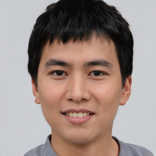 Joyful asian young-adult male with short  black hair and brown eyes