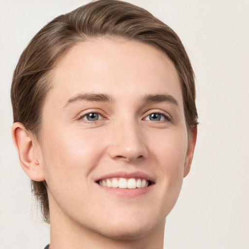 Joyful white young-adult male with short  brown hair and grey eyes