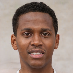 Joyful black young-adult male with short  brown hair and brown eyes