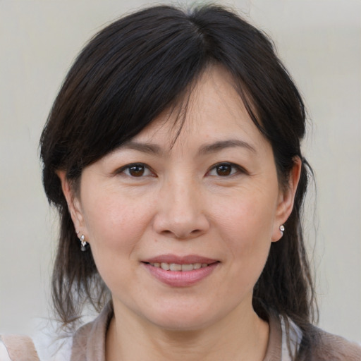 Joyful white adult female with medium  brown hair and brown eyes