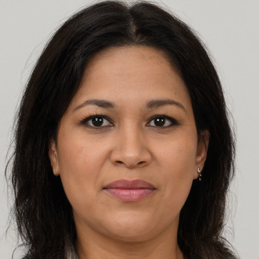 Joyful latino adult female with long  brown hair and brown eyes