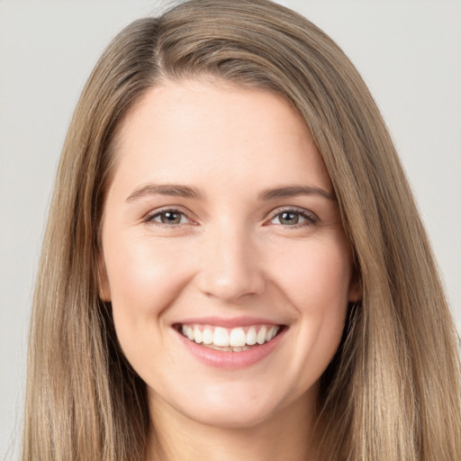 Joyful white young-adult female with long  brown hair and brown eyes