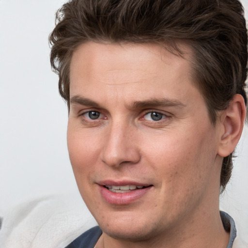 Joyful white young-adult male with short  brown hair and grey eyes