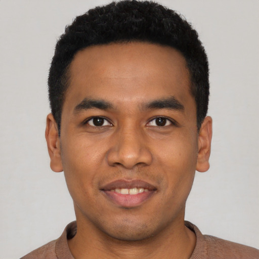 Joyful latino young-adult male with short  black hair and brown eyes