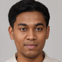 Joyful latino young-adult male with short  black hair and brown eyes