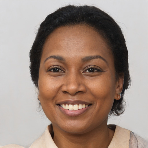 Joyful black adult female with medium  brown hair and brown eyes
