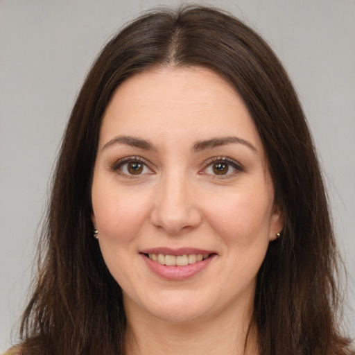 Joyful white young-adult female with long  brown hair and brown eyes