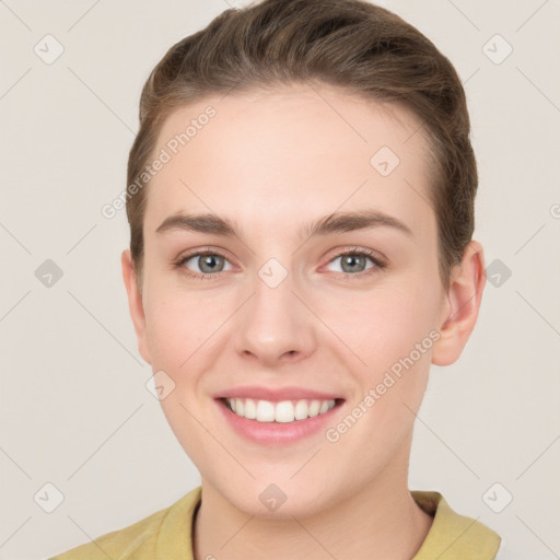 Joyful white young-adult female with short  brown hair and grey eyes