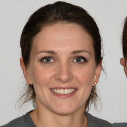 Joyful white young-adult female with medium  brown hair and blue eyes