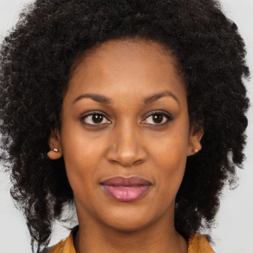 Joyful black young-adult female with long  brown hair and brown eyes