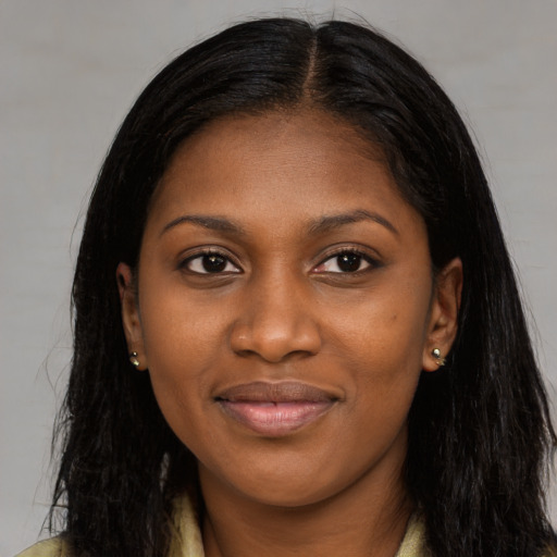 Joyful black young-adult female with long  black hair and brown eyes