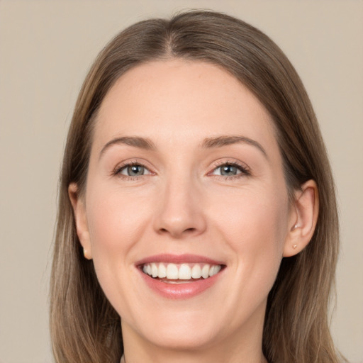 Joyful white young-adult female with long  brown hair and grey eyes