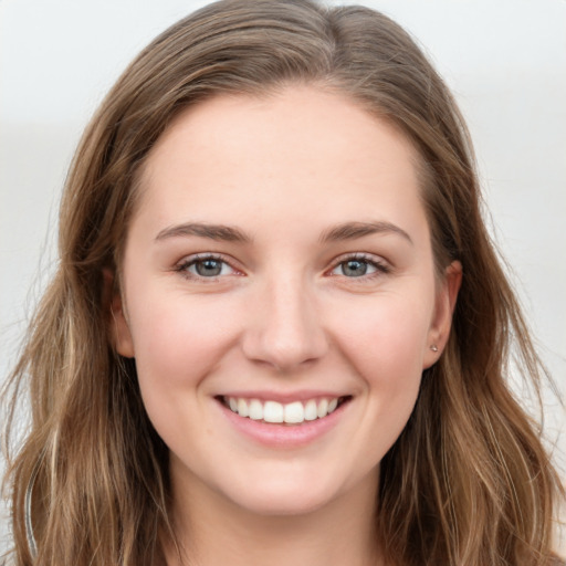 Joyful white young-adult female with long  brown hair and grey eyes