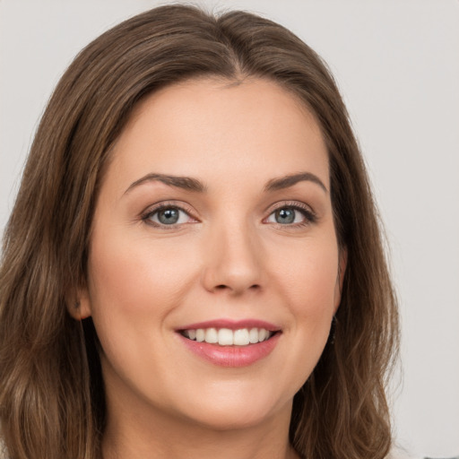 Joyful white young-adult female with long  brown hair and green eyes