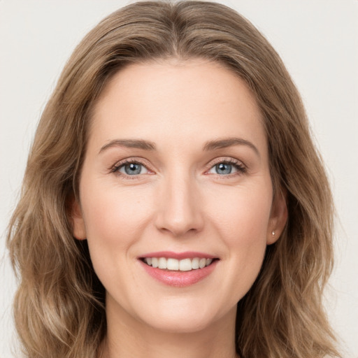 Joyful white young-adult female with long  brown hair and green eyes