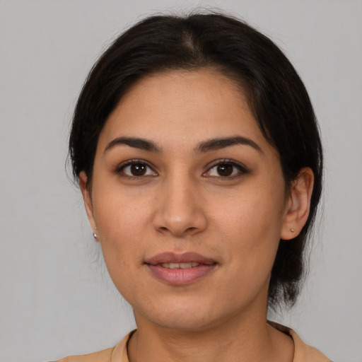 Joyful latino young-adult female with medium  brown hair and brown eyes